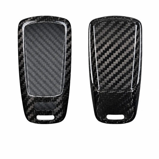 Two black carbon fiber key fob covers shown from the front and back, featuring a glossy woven carbon fiber pattern and a clear protective film on the left side, set against a plain white background.