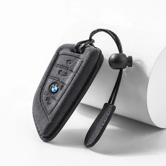 Suede key fob cover for BMW with keychain on a white background