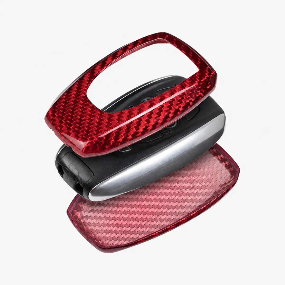 A pair of glossy carbon fiber key fob covers in red, shown on a white background.