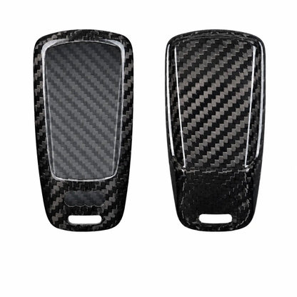 Two black carbon fiber key fob covers shown from the front and back, featuring a glossy woven carbon fiber pattern and a clear protective film on the left side, set against a plain white background.