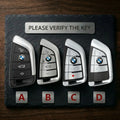 Four BMW key fobs on a slate surface with text 'Please Verify The Key'.