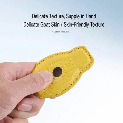 A hand holding a small yellow leather key fob cover or protector against a light blue gradient background, with text at the top reading 'Delicate Texture, Supple in Hand' and 'Delicate Goat Skin / Skin-Friendly Texture'.