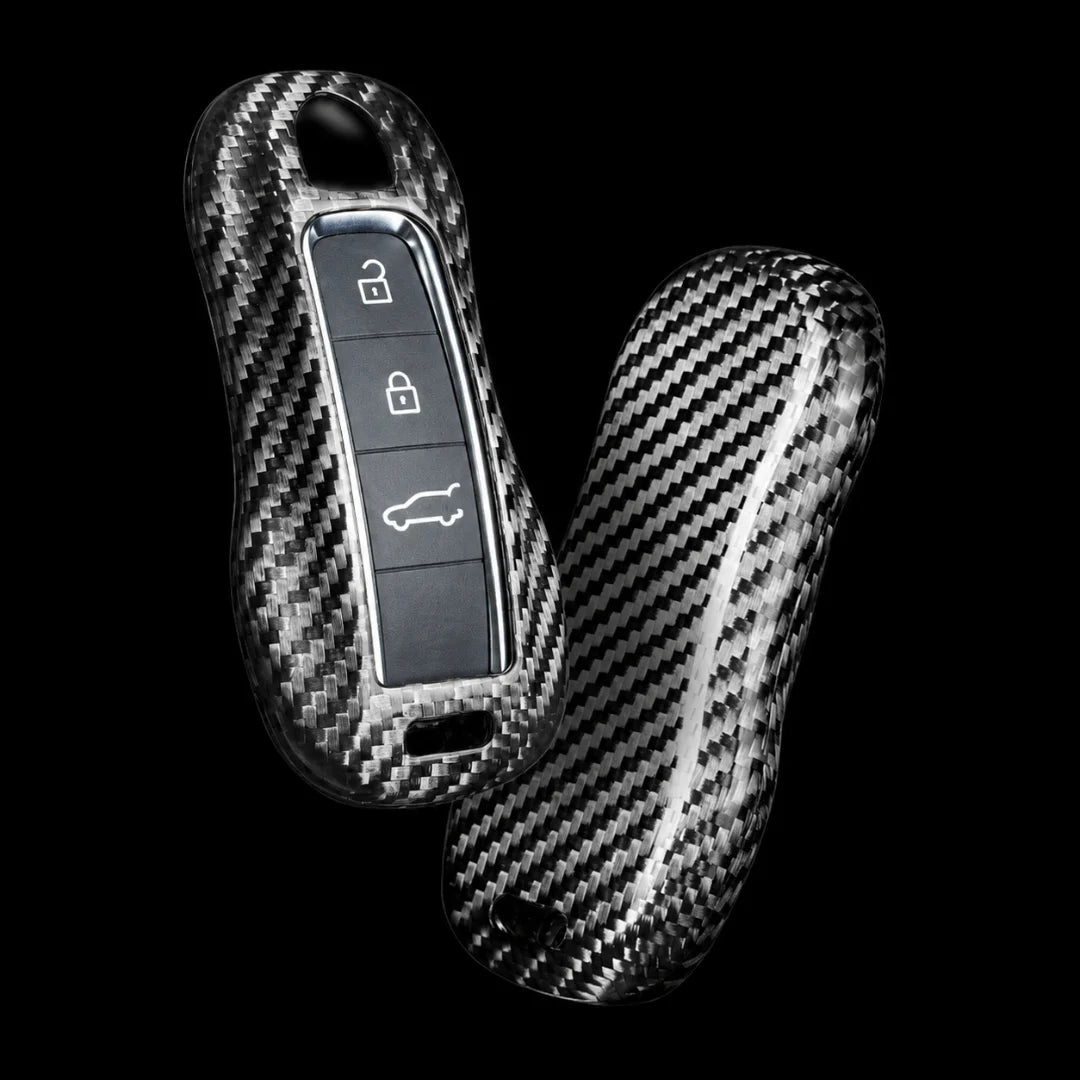 Two carbon fiber key case covers with a glossy woven pattern, shown on a solid black background.