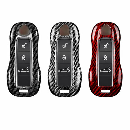 Three car key fob covers with a glossy carbon fiber pattern, shown side by side on a plain white background. The left cover is black and dark gray, the middle is black and silver, and the right is red and black.
