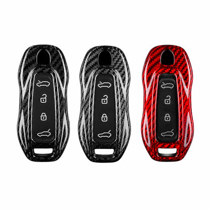 Three car key fob covers with a glossy carbon fiber pattern, shown side-by-side in black, silver, and red on a plain white background.