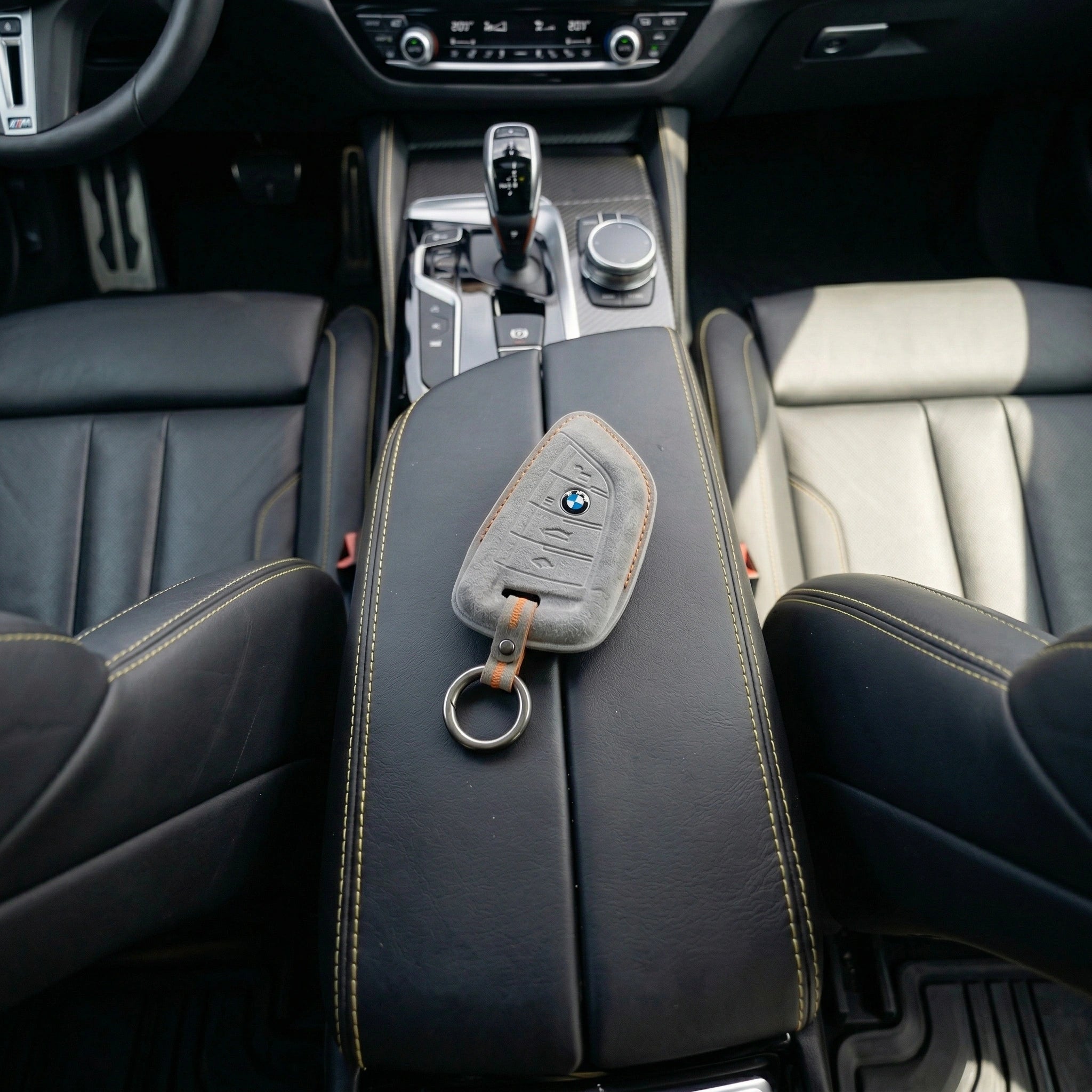 Light gray alcantara key cover with bmw logo in middle in luxury car